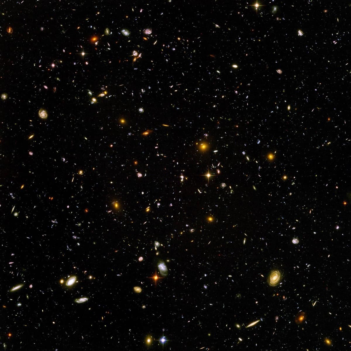 A black sky scattered with thousands of small, colorful galaxies.